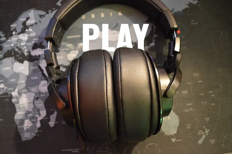 Over-ear headphones with the word PLAY in white Oswald letters inside the headband